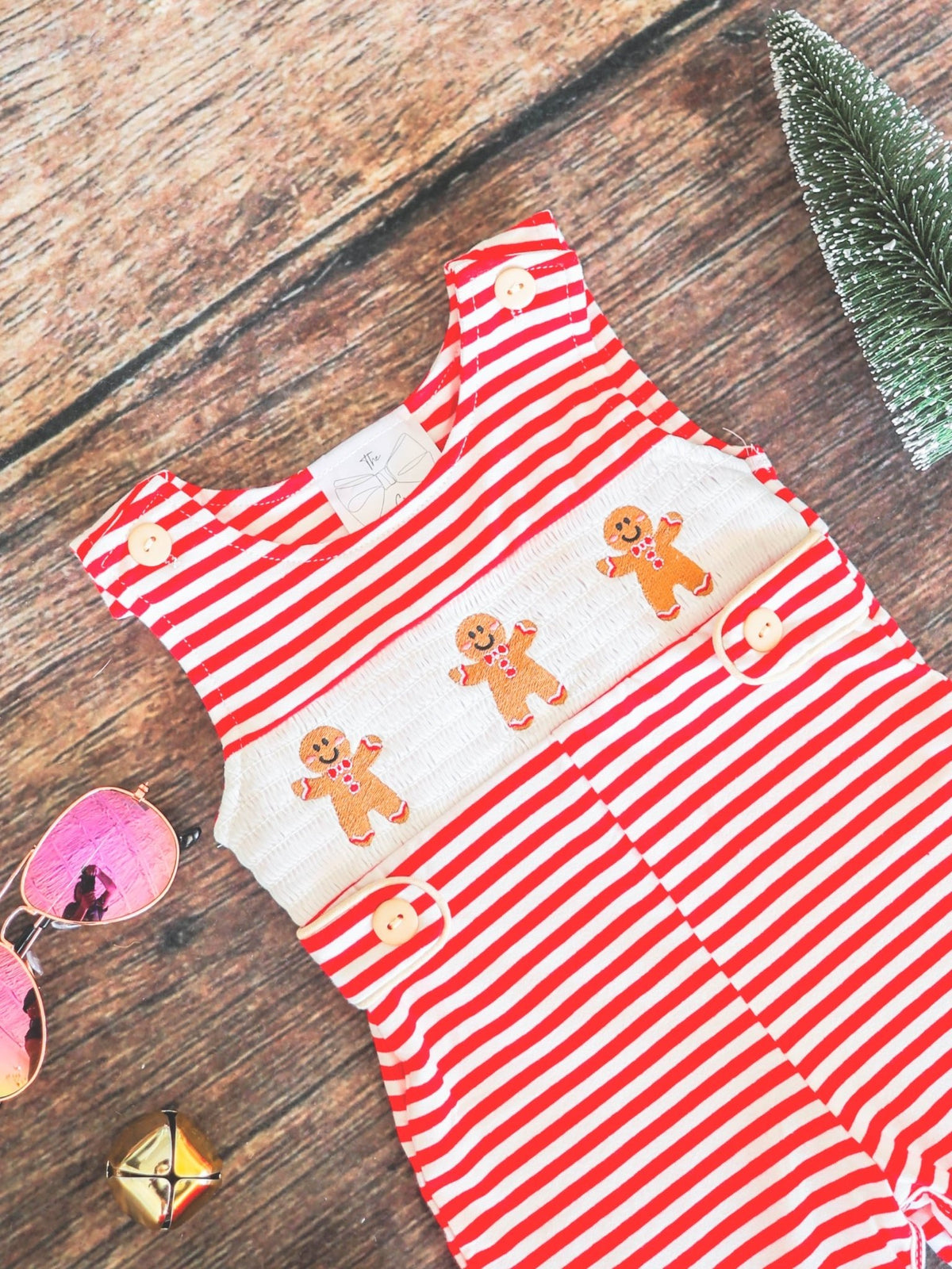 Close-up of the gingerbread friends design on a red striped infant boys onesie