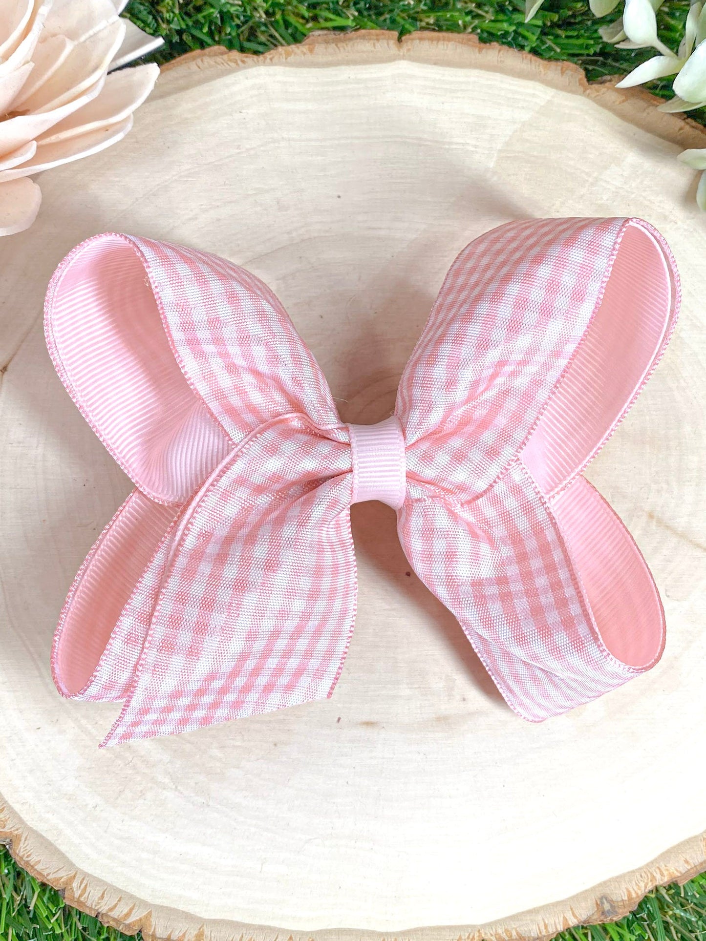 Pink gingham bow on a wooden surface 