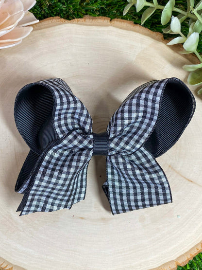 black and white gingham bow on a wooden surface 
