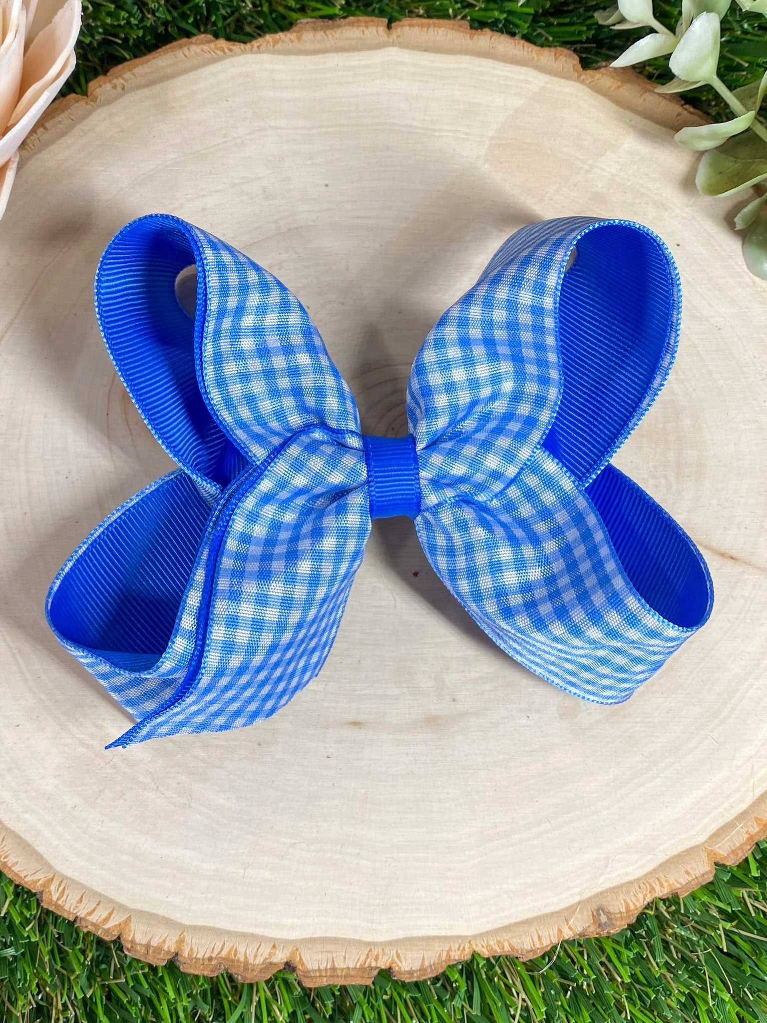 royal blue gingham hair bow on a wooden surface