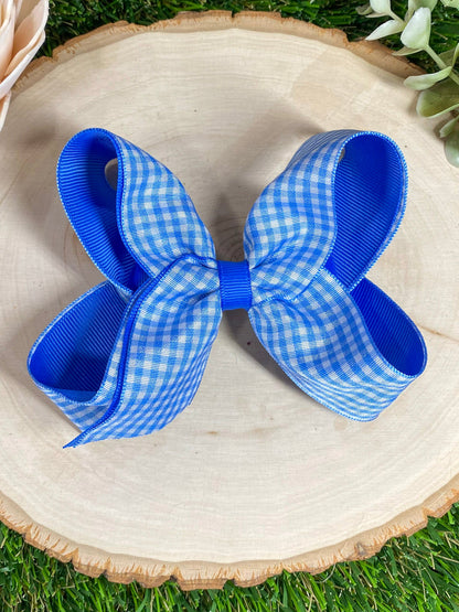 royal blue gingham hair bow on a wooden surface