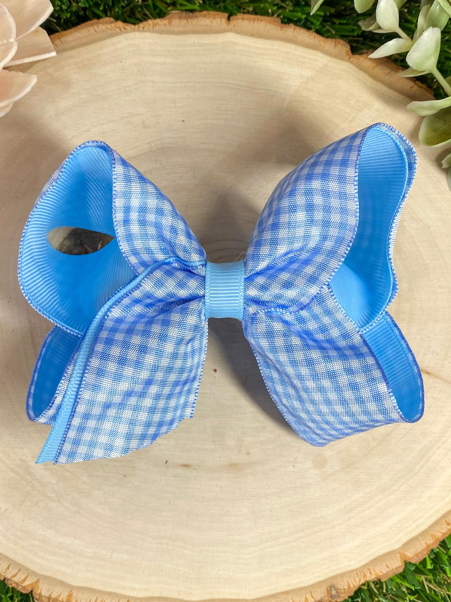 Blue gingham bow on a wooden surface 