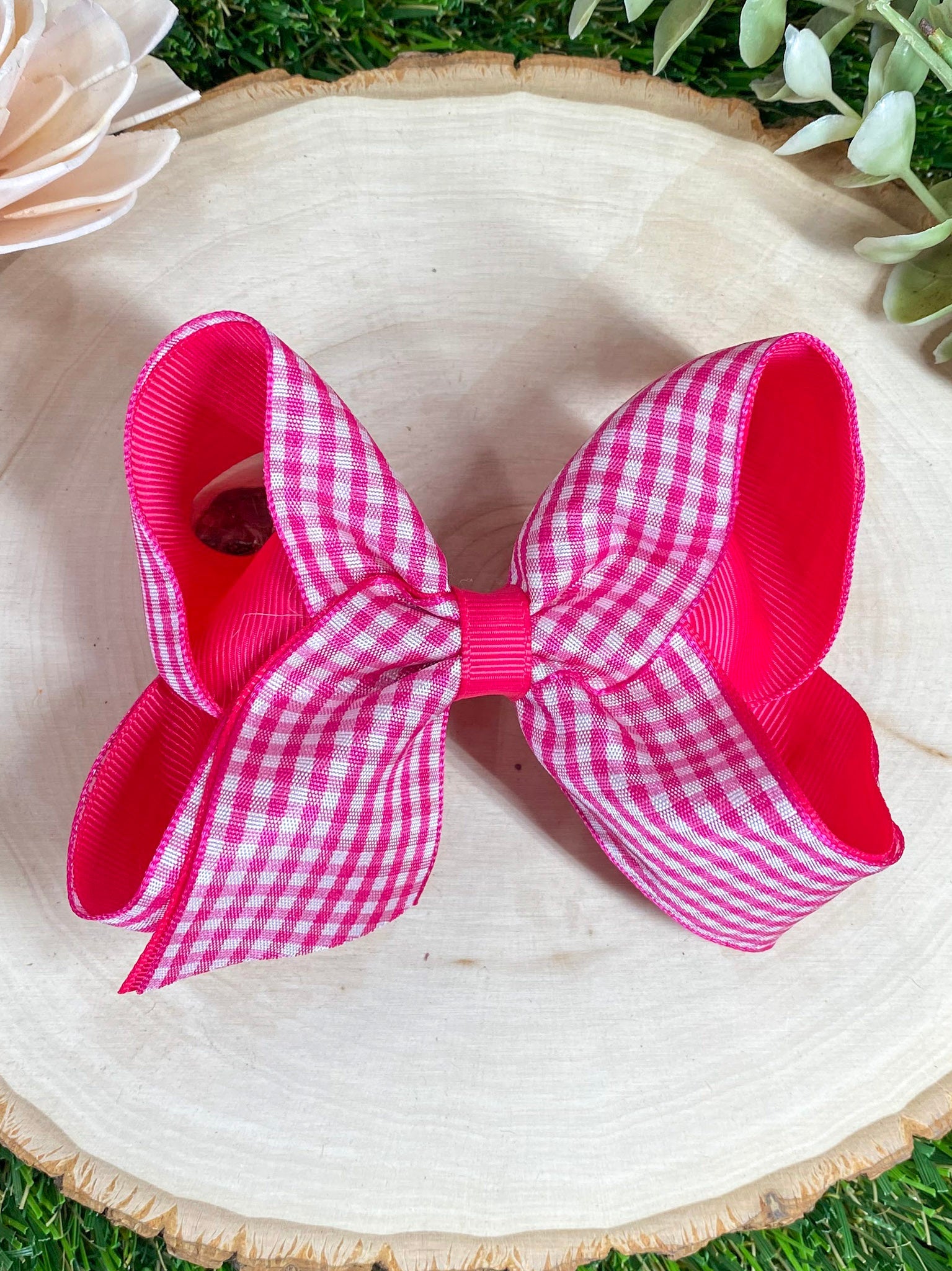 Hot Pink gingham bow on a wooden surface 