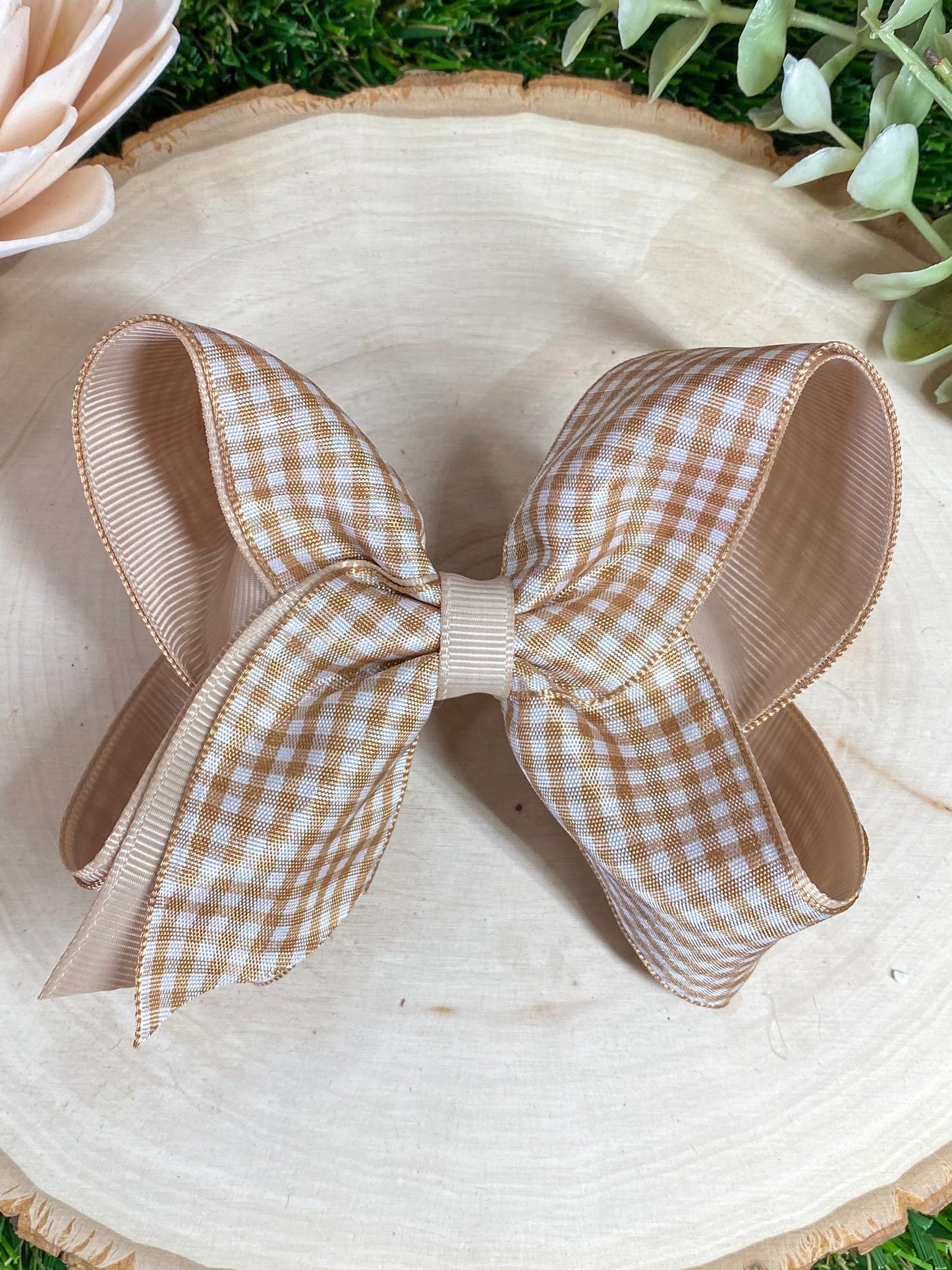 Oatmeal gingham bow on a wooden surface 