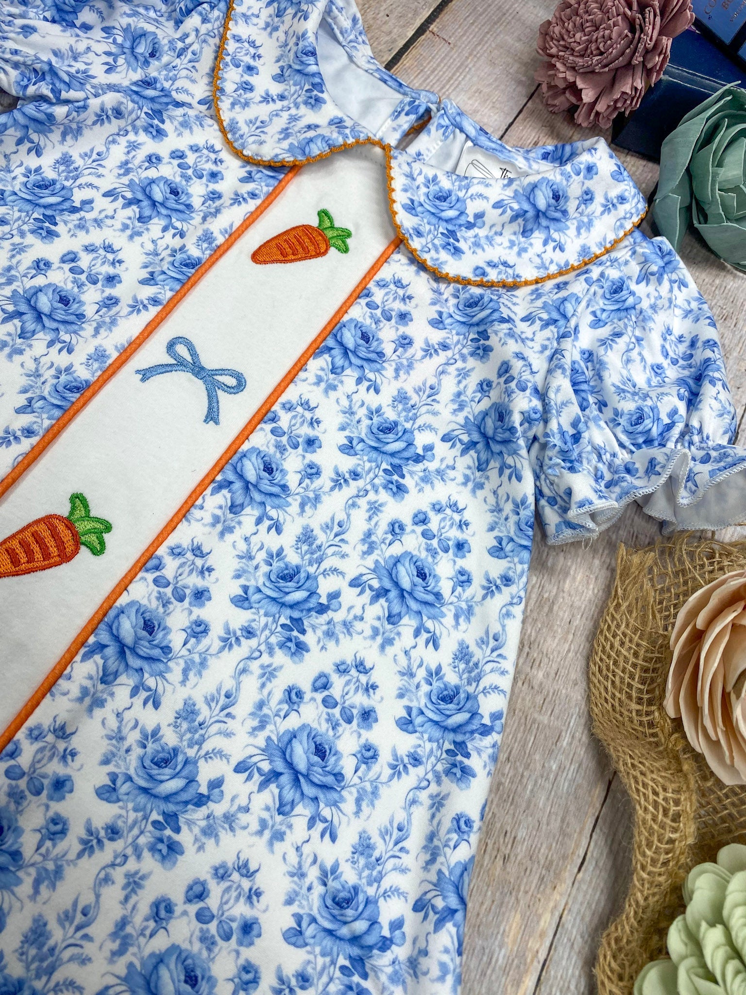 Blue floral dress with white apron on a wooden surface