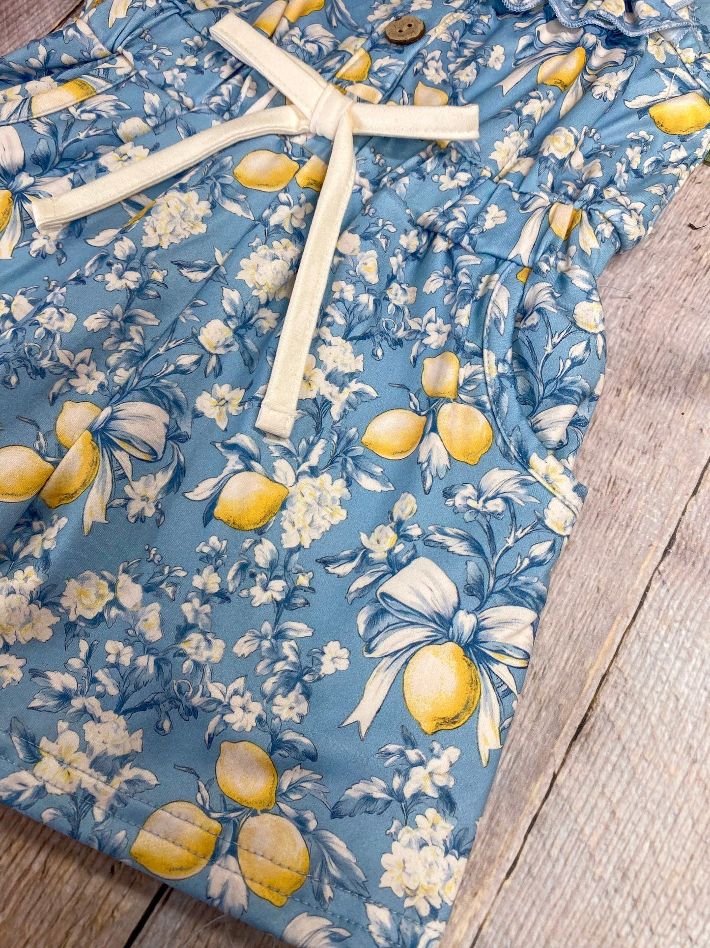 lemon print on romper on wood background