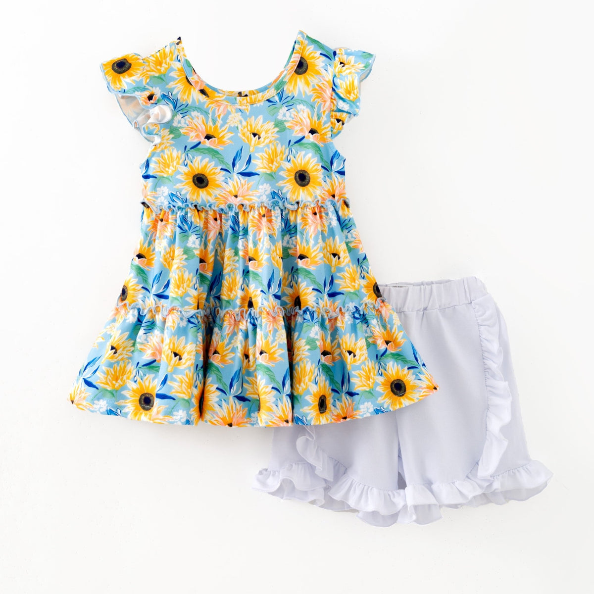 Blue sunflower top and ruffled shorts on white