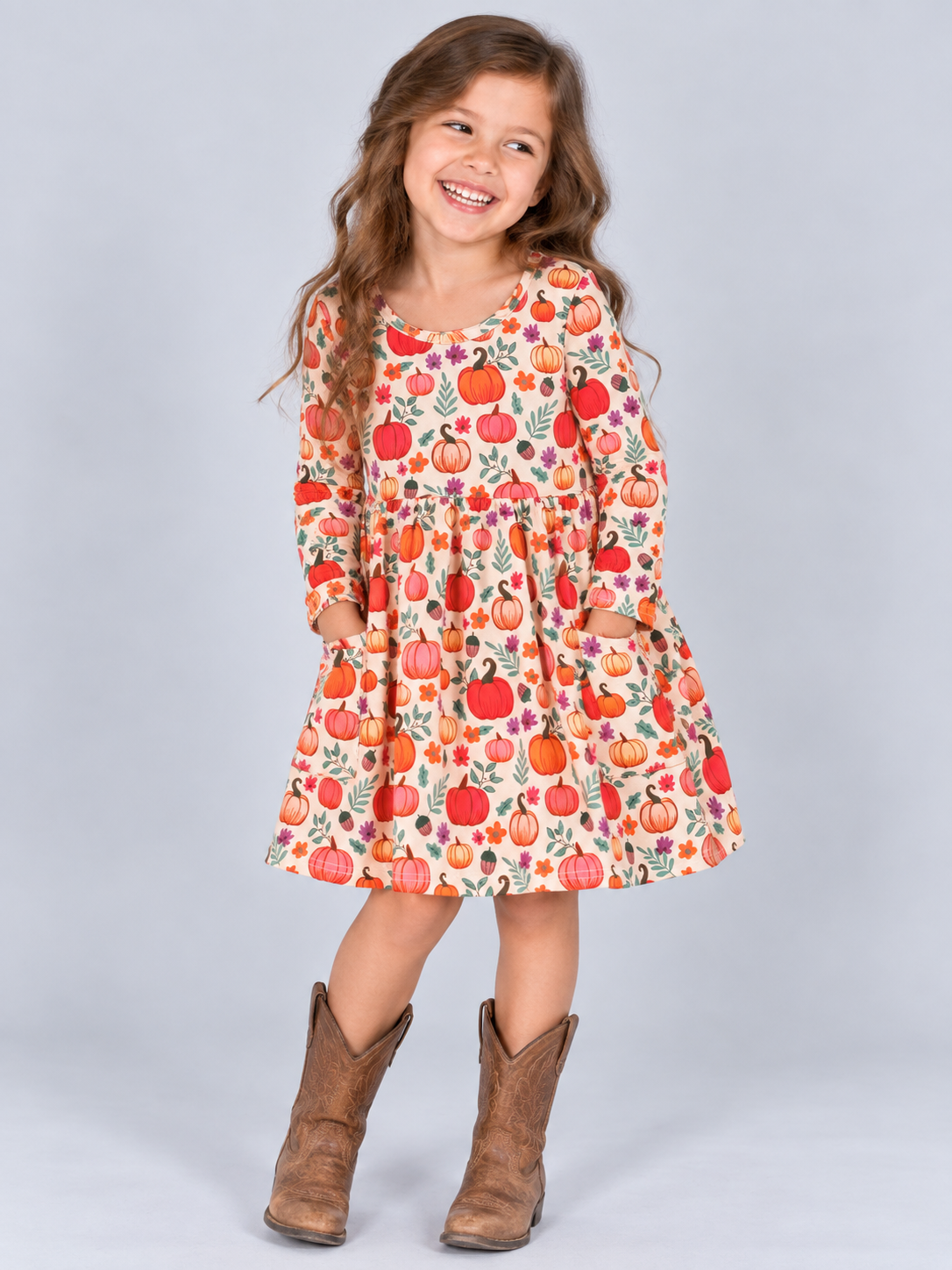 Girl wearing a fall pumpkin floral pocket dress in pink and orange tones