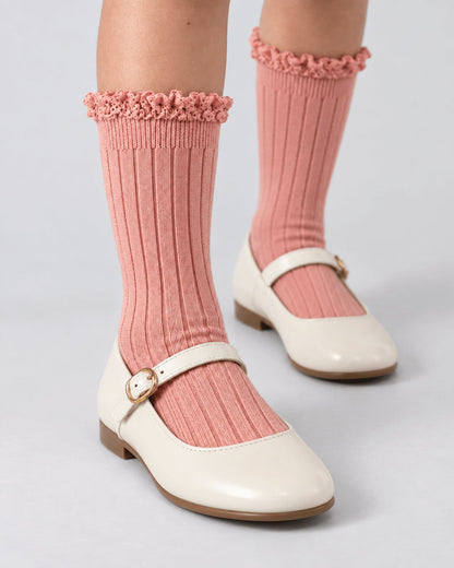 Pink ruffle knee socks worn with cream Mary Janes