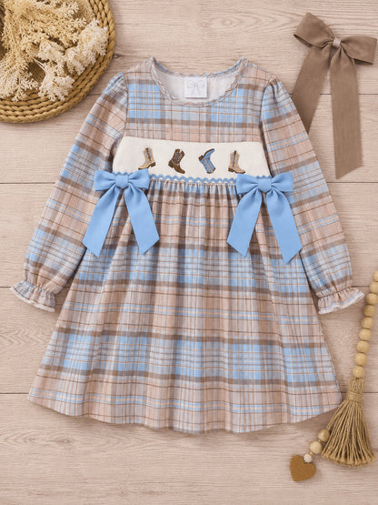 Cowboy boots smocked dress laid flat on wood