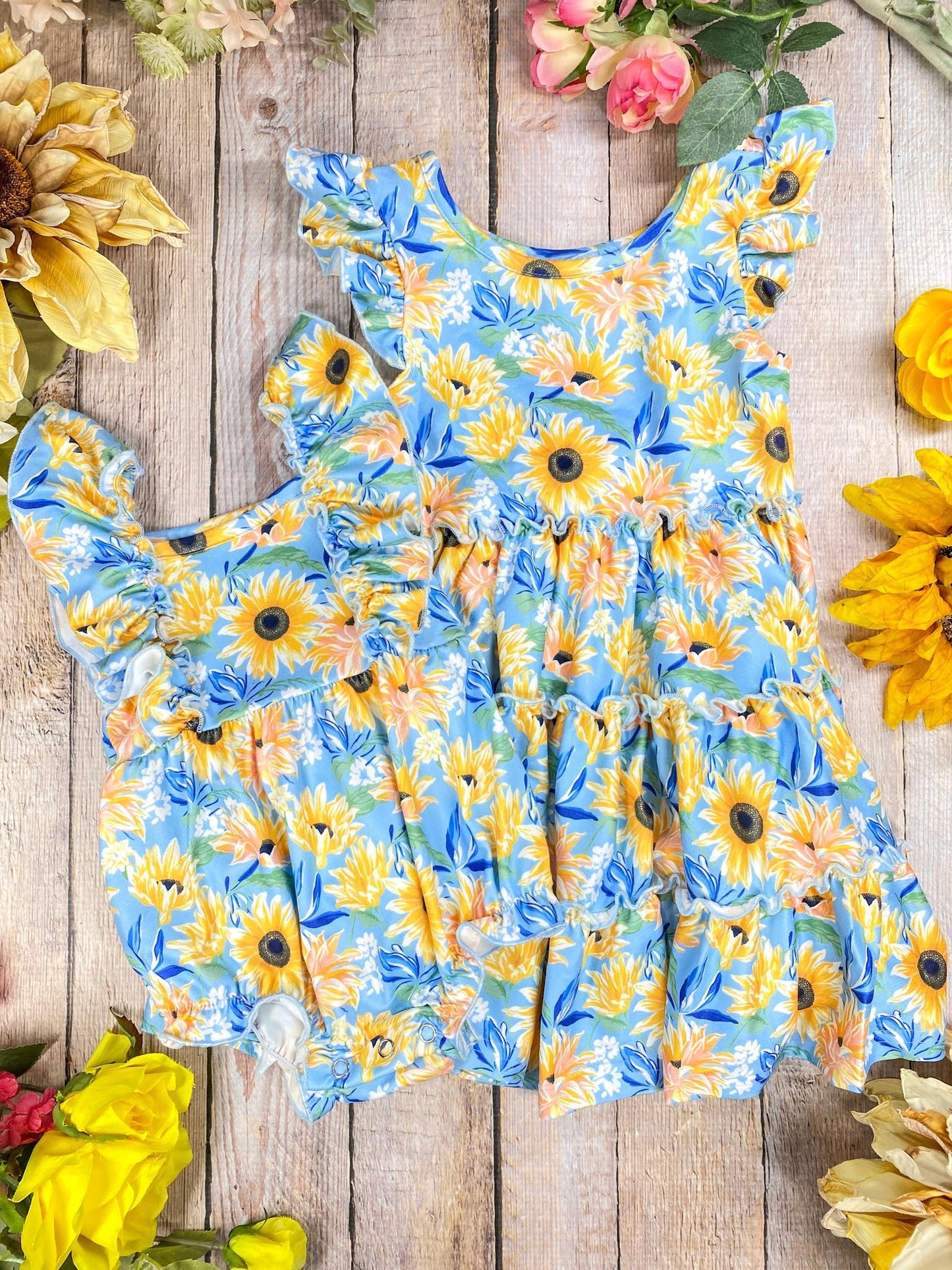 Children's sunflower dress on a wooden surface & romper with sunflowers around