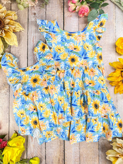 Children's sunflower dress on a wooden surface & romper with sunflowers around