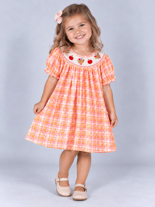 Girl wearing the pink and orange plaid turkey dress