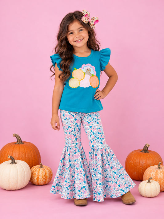 Teal turkey top and floral bell bottoms on white on pink wall with pumpkins