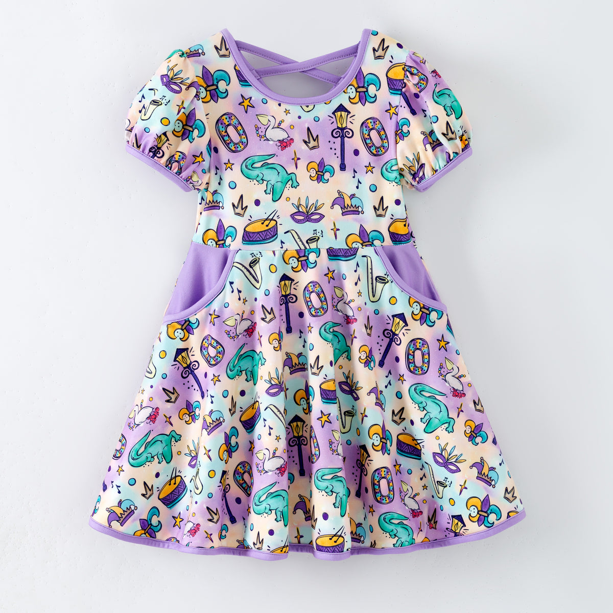 Mardi gras children's boutique dress with designs on a white background