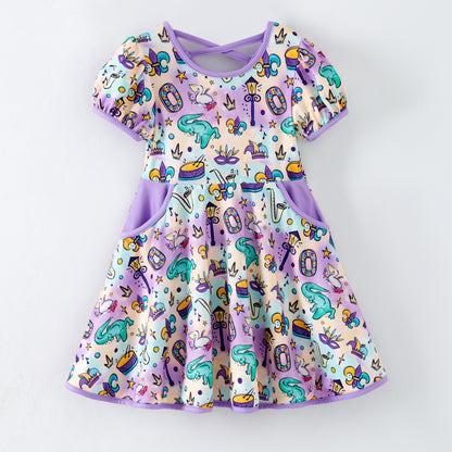 Mardi gras children's boutique dress with designs on a white background