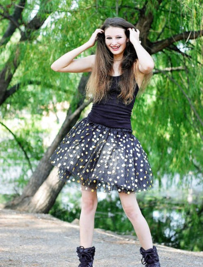 Woman wearing a black plus size tutu with gold dots