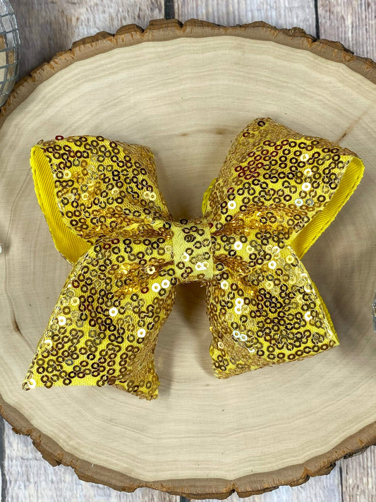 Gold sequin bow on a wooden surface