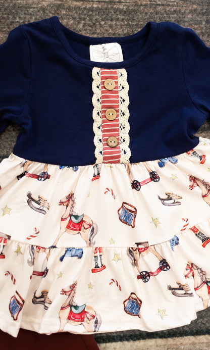 close up of the shirt, showing decorative buttons and the vintage toy patterns of nutcrackers and rocking horses and drums