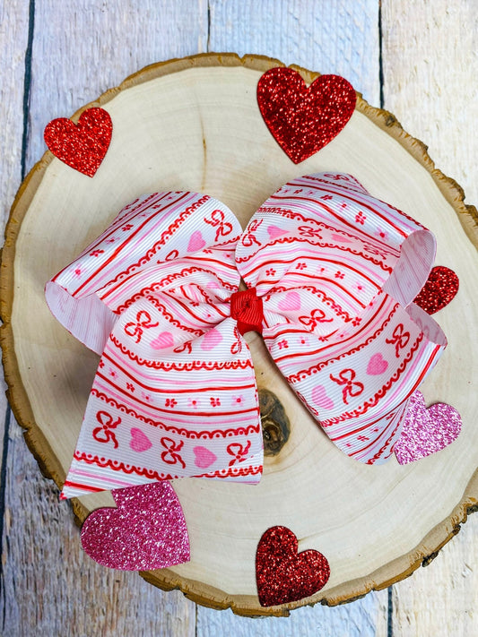 Two decorative bows with heart patterns on a wooden surface.