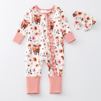 Baby onesie with cow and flower pattern on a white background