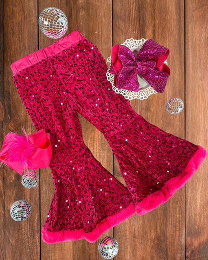 Hot pink sequin leggings with a large pink bow on a wooden surface