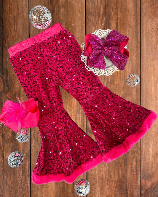 Hot pink sequin leggings with a large pink bow on a wooden surface