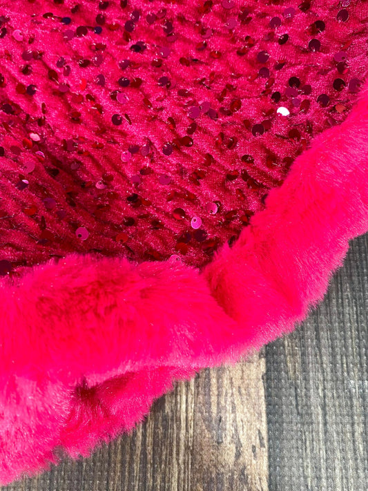Close-up of a pink textured fabric with sequins on a wooden surface - Alternative view