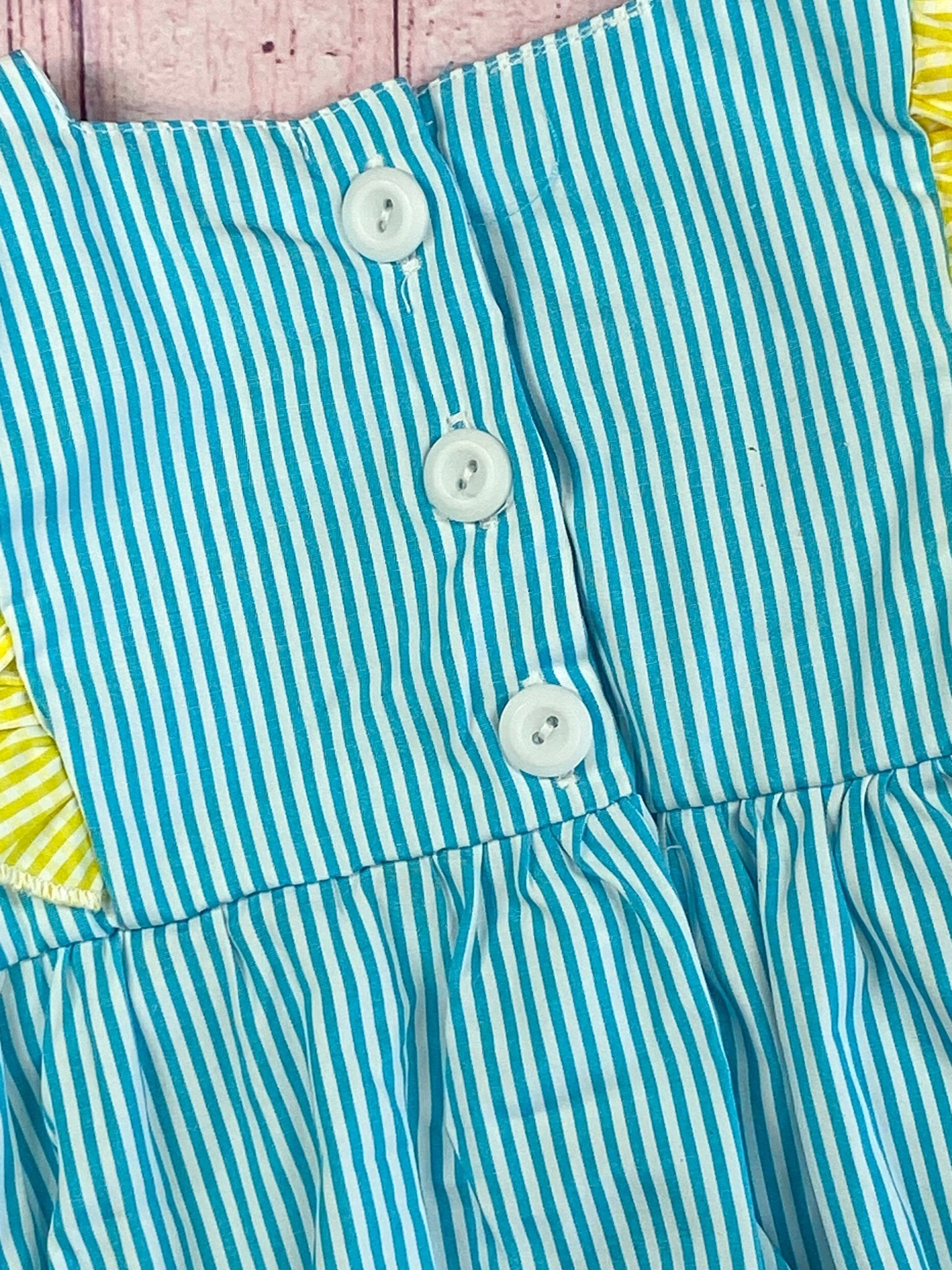 Close up detail photo of the buttons on back of romper