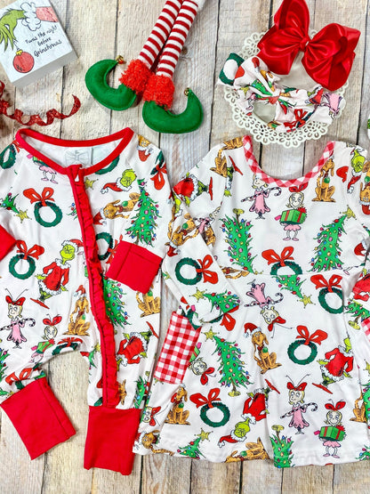 Matching Grinch-themed baby romper and girls’ long sleeve twirl dress featuring a white background with colorful all-over prints of classic Dr. Seuss Grinch characters, red bows, wreaths, and Christmas trees. The romper has red trim, cuffs, and a front ruffle zip closure, while the dress includes red and white gingham side pockets and a scoop neckline.