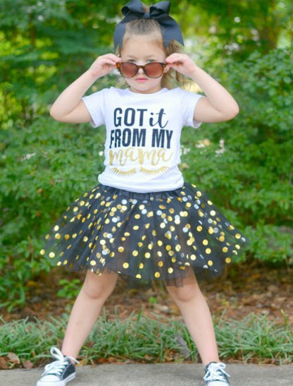 model wearing girls black and gold dot tutu outside