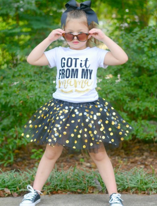 model wearing girls black and gold dot tutu outside