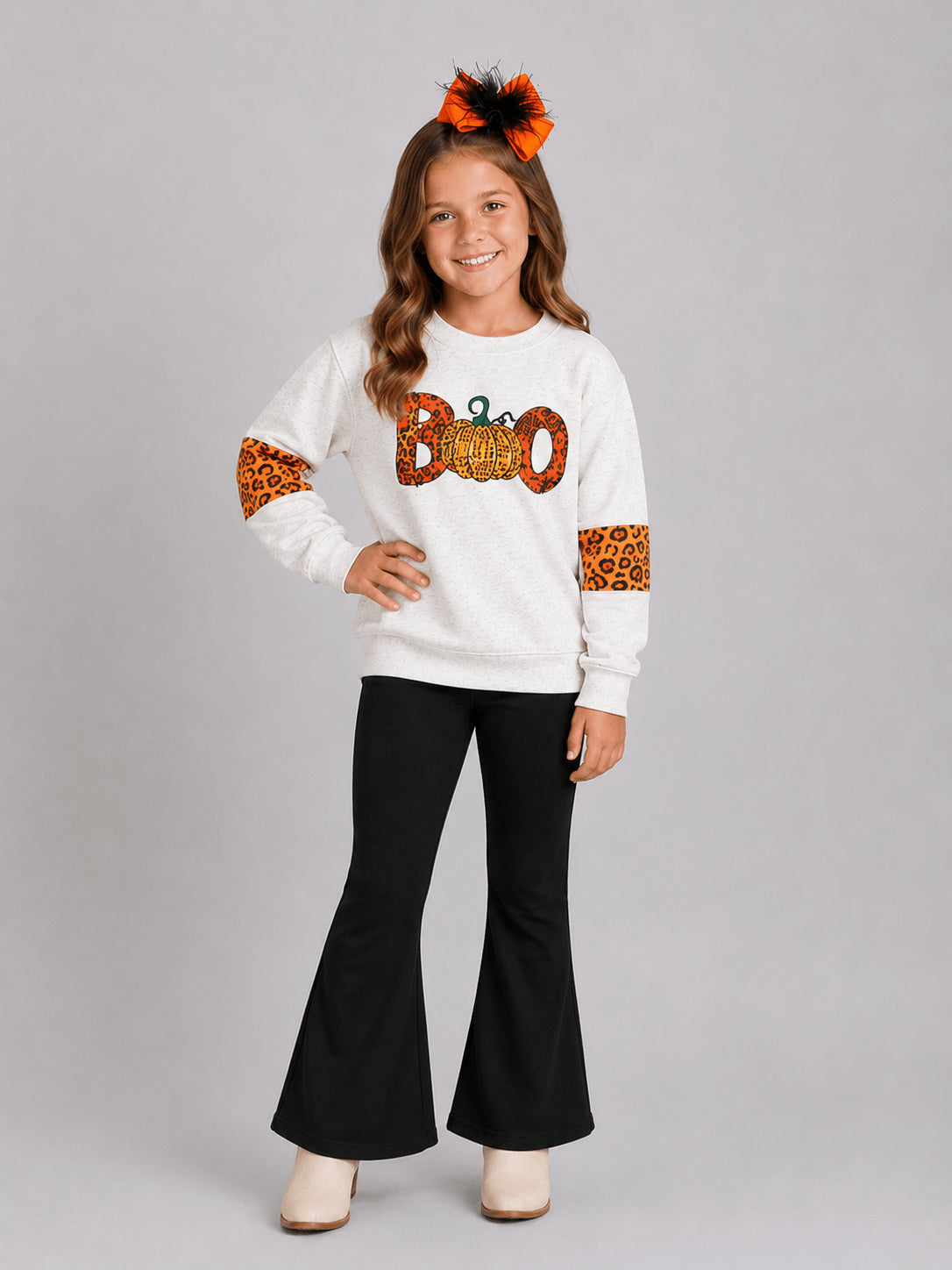 Girl wearing a Halloween top with a leopard Boo and pumpkin