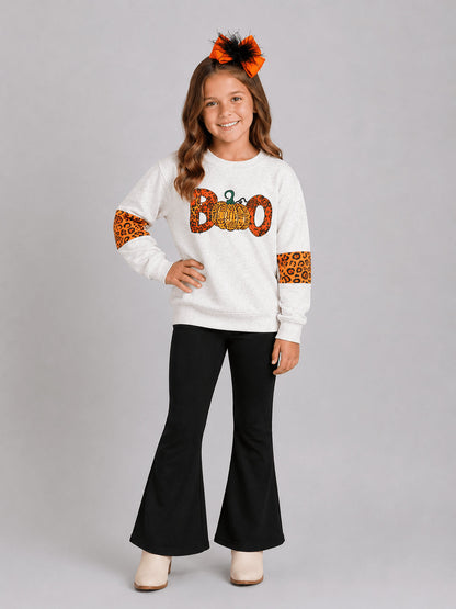 Girl wearing a Halloween top with a leopard Boo and pumpkin