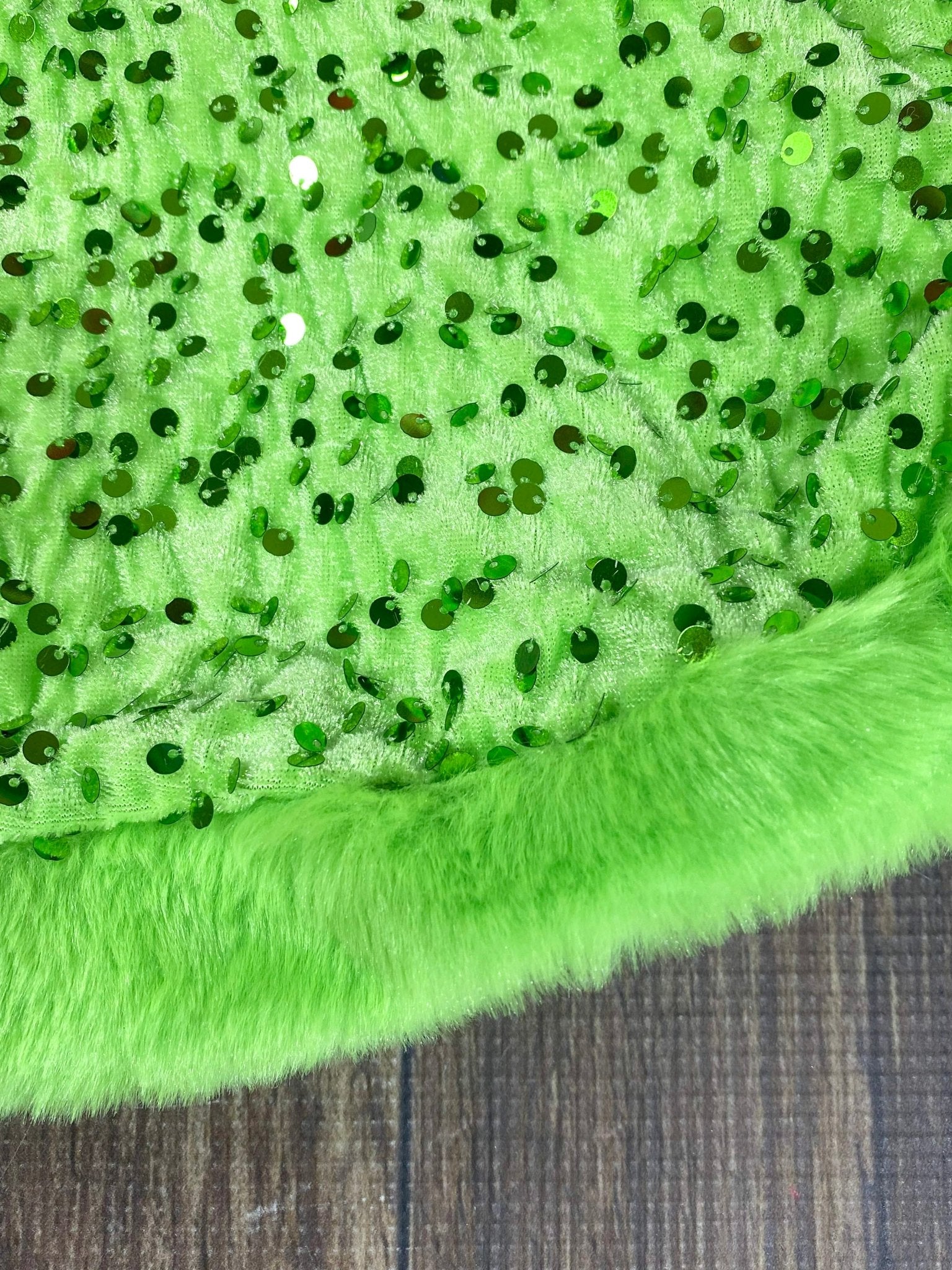 Close-up of green fabric with sequins on a textured surface