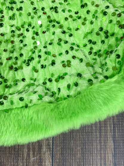 Close-up of green fabric with sequins on a textured surface