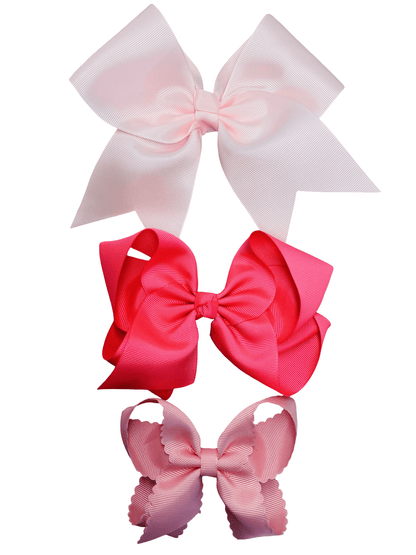 Three large hair bows in pinks on a white background
