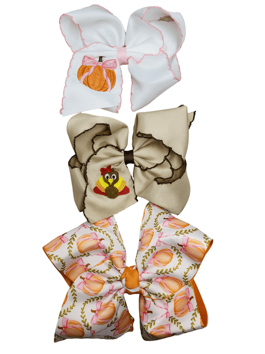 Three decorative bows with different fall patterns on a white background - Alternative view