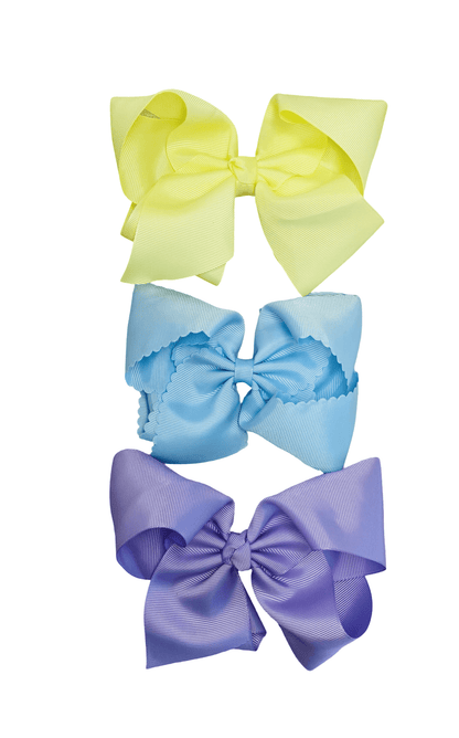 Three colorful hair bows in yellow, blue, and purple on a white background