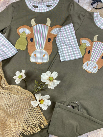 boys western long sleeve top and romper with cow appliqué and faux gingham layered sleeve accents on a wooden background