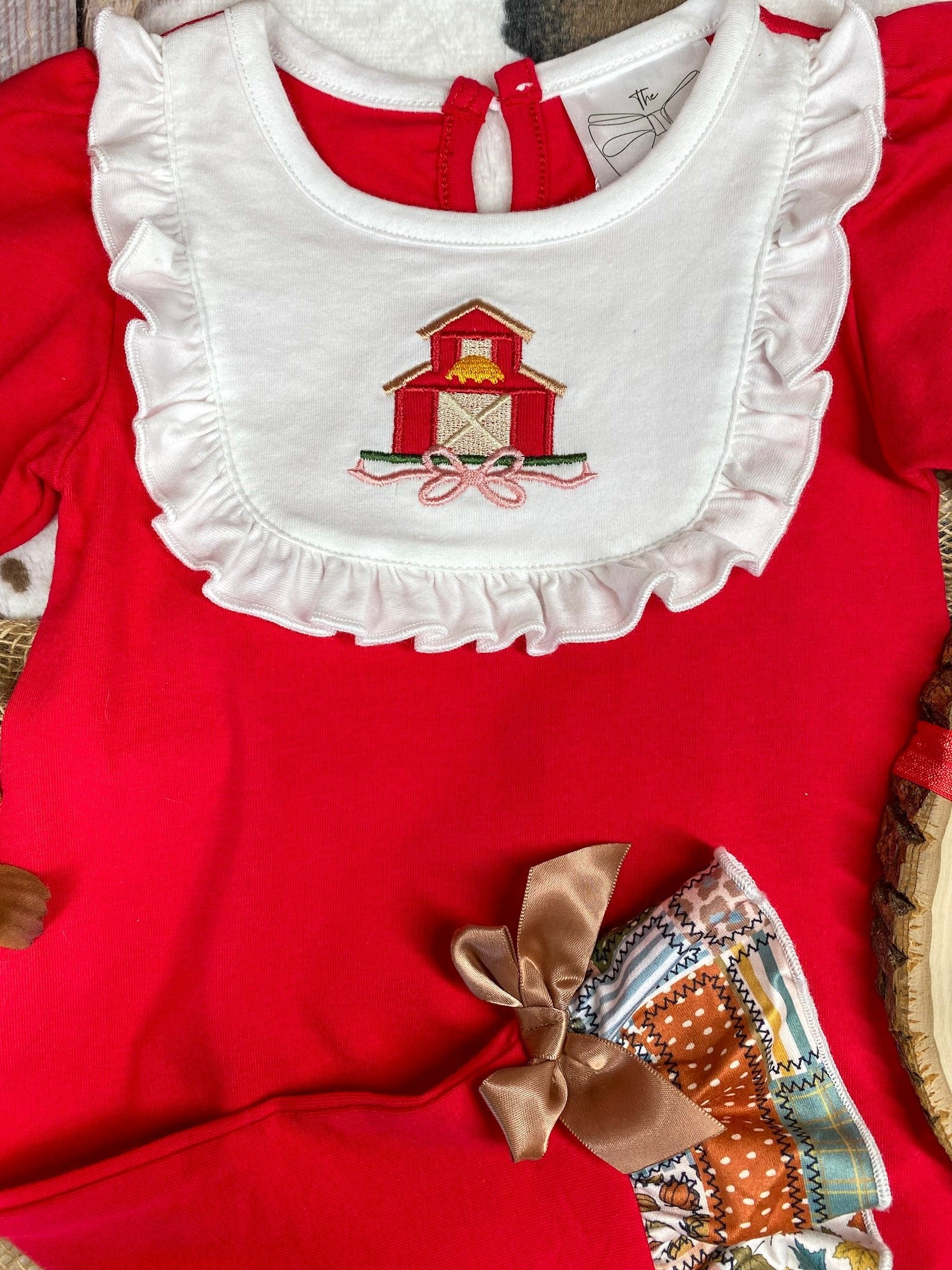 baby girl fall one-piece with barn appliqué ruffle bib and patchwork ruffle leg hems