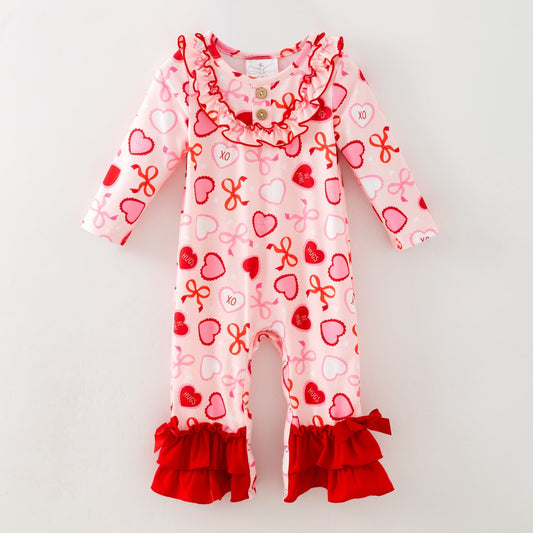 Children's onesie with heart and bow pattern on a white background
