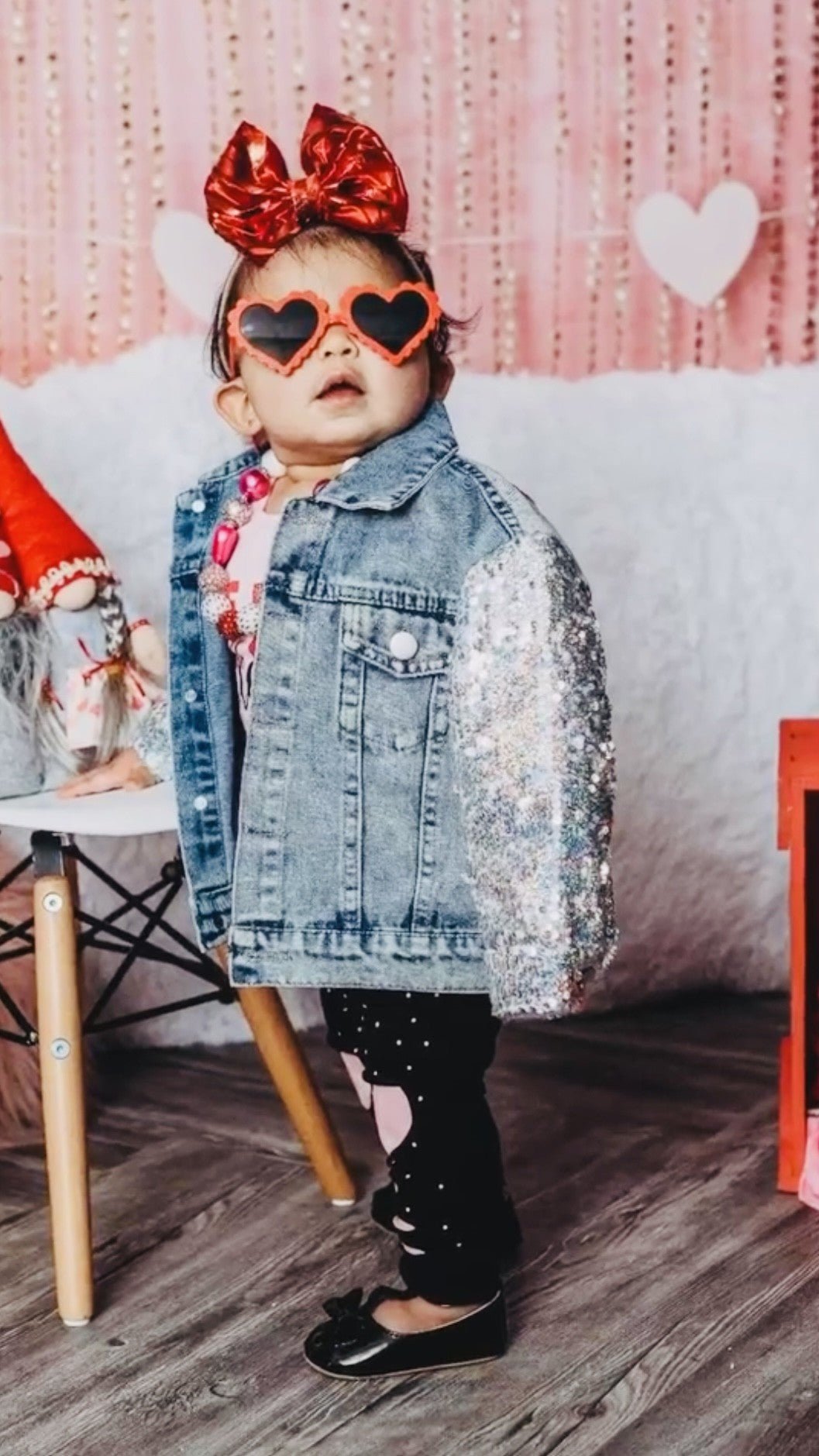 Girl in the sequin sleeve jean jacket and heart sunglasses