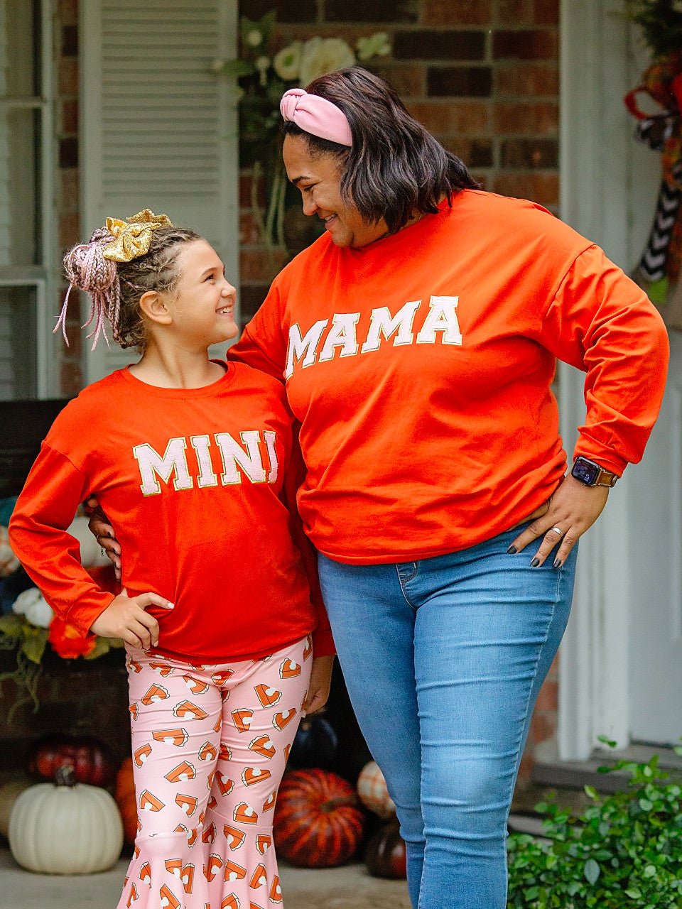 Mom and daughter wearing orange Mama and Mini shirts
