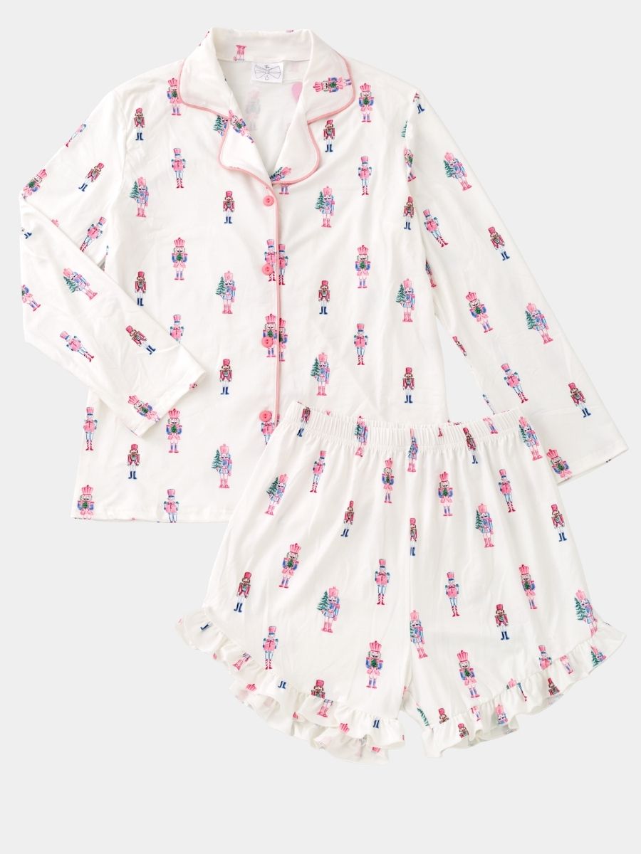 Women's Pink Nutcracker Christmas pajama set with pastel nutcracker print, button-front top, and ruffle shorts.
