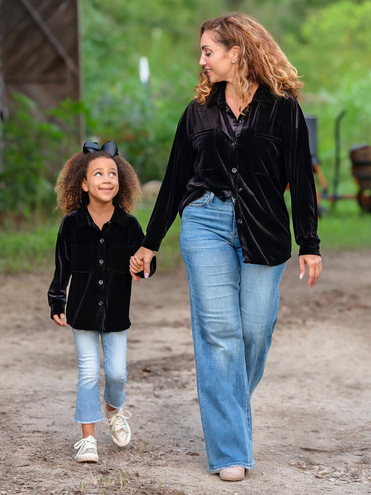 Mom and daughter wearing matching black velvet button down tops