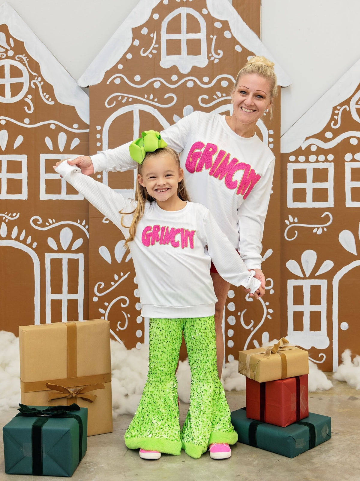 Mom and daughter wearing matching Grinchy chenille Christmas sweatshirts