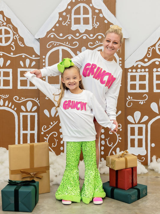 Mom and daughter wearing matching Grinchy chenille Christmas sweatshirts