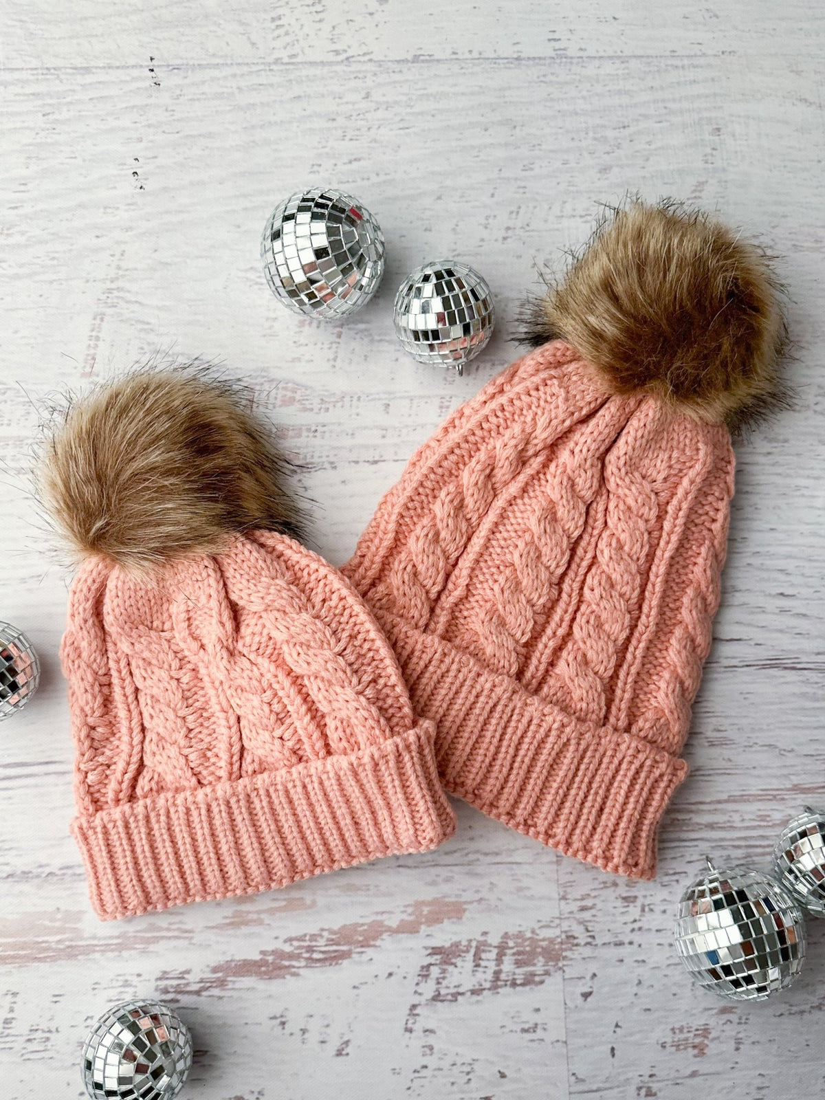 Matching mom and girl light pink knit beanies with fur poms