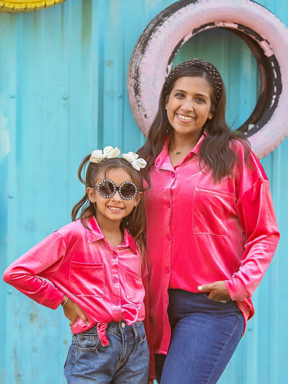 Mom and daughter in matching pink velvet button-down tops